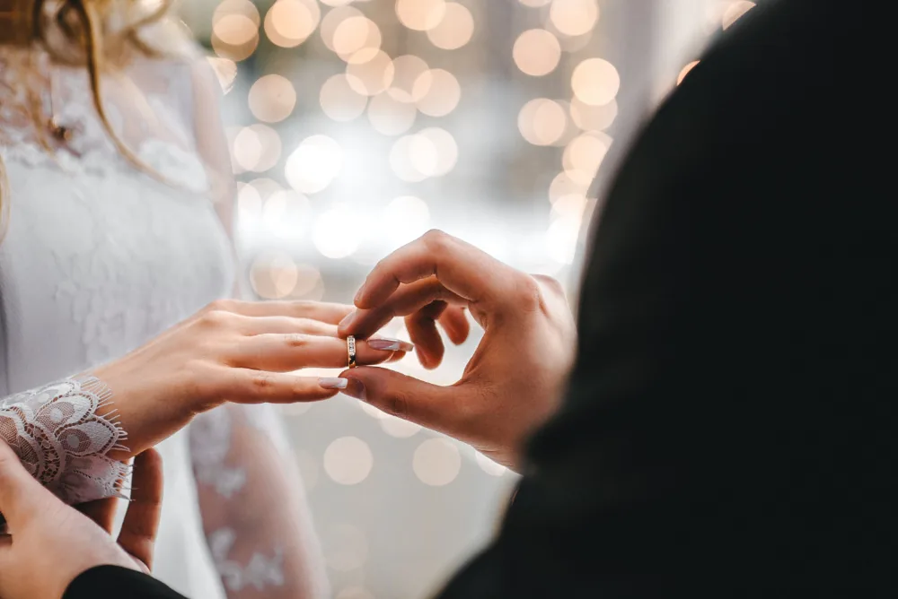 A groom putting a ring on the bride during a wedding ceremony.