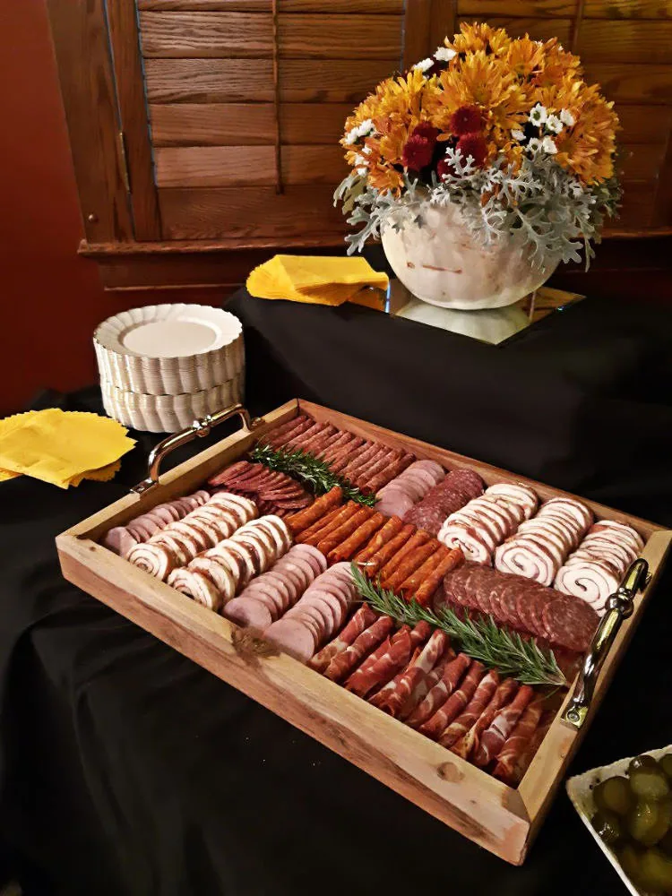 An assortment of deli meats arranged on a wooden serving tray.